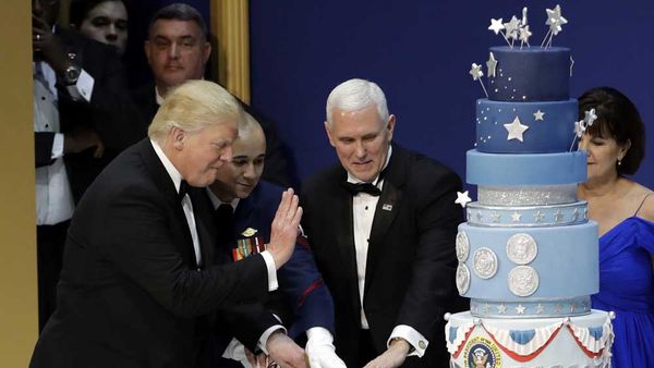 Image: Getty. Trump cuts the controversial inauguration cake during the Armed Services Inaugural Ball in Washington, D.C., on Friday, Jan. 20, 2017