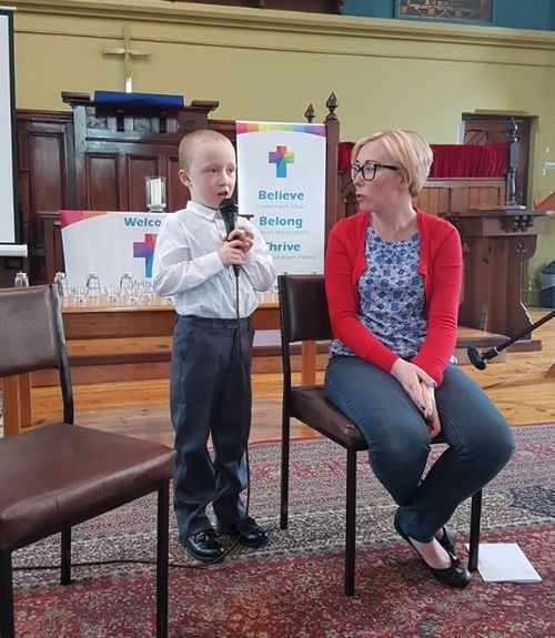 Jack singing in church while his mum watches on. 
