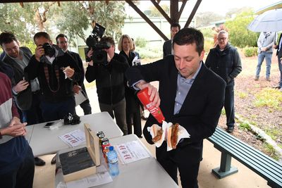 Victorian Opposition Leader Matthew Guy saucing up a democracy sausage on the final day of the Victorian election campaign.