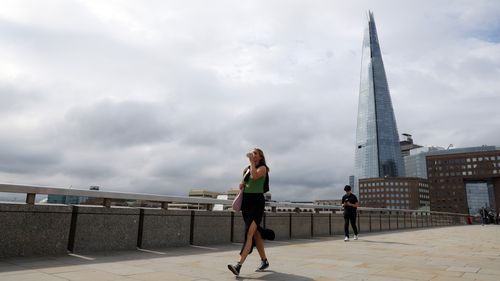 Commuters cross London Bridge in London.