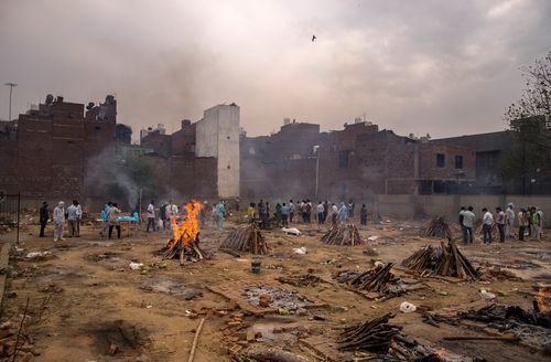 Multiple funeral pyres burn at a ground converted into a makeshift crematorium in New Delhi, India.