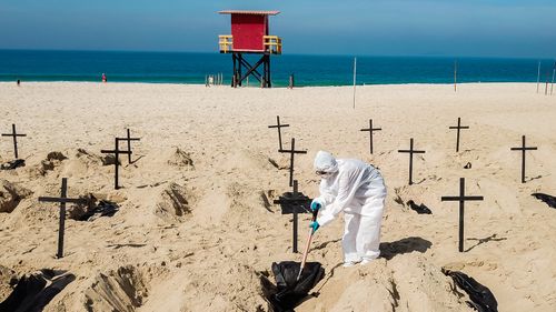 Protesters from the NGO 'Rio De Paz' dig symbolic graves as a sign of protest in Copacabana beach in Rio de Janeiro, Brazil. Volunteers dug 100 shallow graves symbolising the deaths of coronavirus in the country. The act calls for transparency and an attitude change from the government to fight the pandemic. 