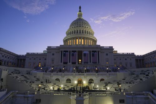 The sun rises behind the US Capitol as an inauguration rehearsal begins 