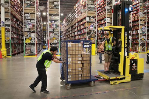 Workers pack customer orders at an Amazon fulfillment centre.