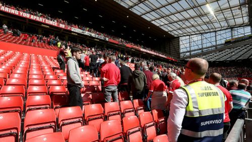 Security escort fans from their seats at Old Trafford. (AAP)