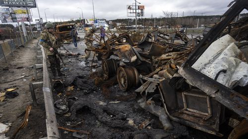 A Ukranian soldier looks at dead Russian soldiers in Bucha, in the outskirts of Kyiv. 