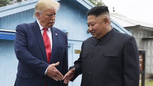 Kim Jong Un and Donald Trump shake hands. 