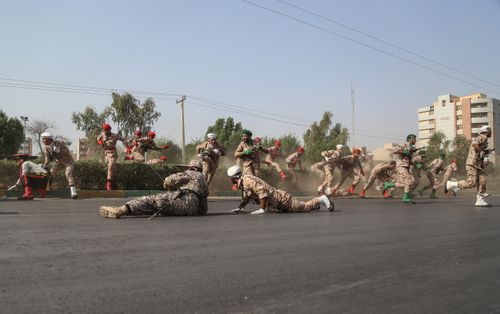 Iranian soldiers, women, and children lay down and run during a terror attack that occurred at military parade in the city of Ahvaz, southern Iran. (AAP)