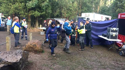 William Callaghan survived two nights of bitterly cold temperatures, wearing just blue tracksuit pants and a hoodie. Here he is seen in a blue jacket, being carried as search party members look on