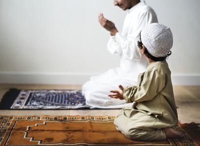 Little boy praying alongside his father during Ramadan Eid Muslim Islam