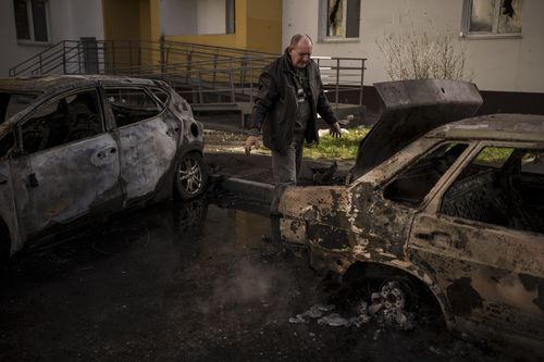 A man looks at his burned car after a Russian attack in Kharkiv, Ukraine, Friday, April 15, 2022. (AP Photo/Felipe Dana)
