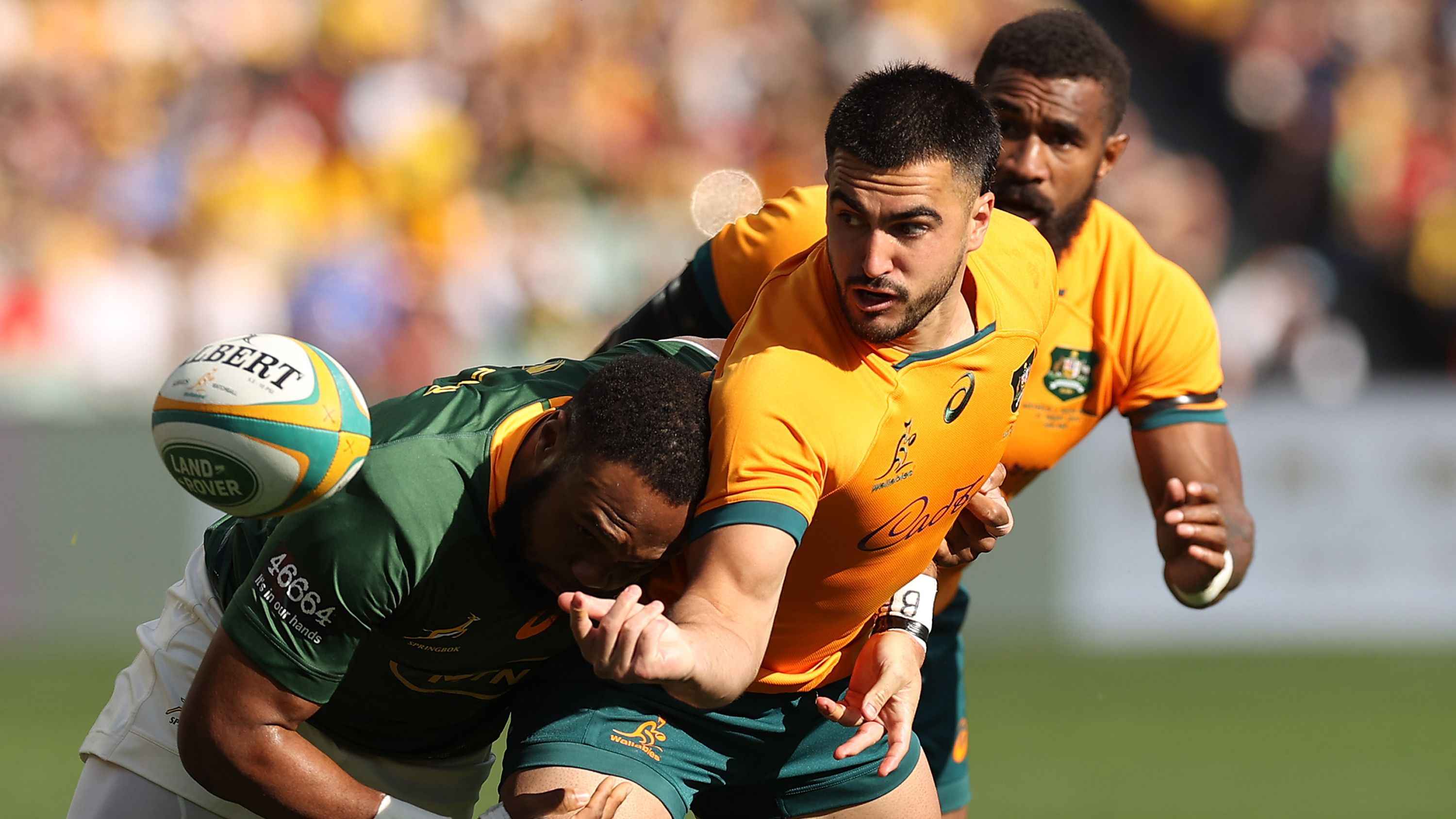 Tom Wright of the Wallabies offloads against the Springboks.