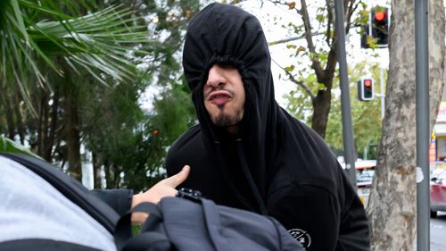 Issa Haddad covered his face with a black hoodie as he left court and yelled at reporters.
