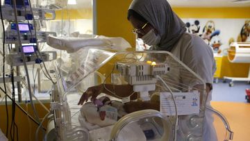 A Moroccan nurse takes care of one of the nine babies protected in an incubator at the maternity ward of the private clinic of Ain Borja in Casablanca, Morocco.