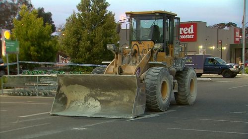 The tractor was used to break the glass shopfront, before dislodging two ATMs. (9NEWS)