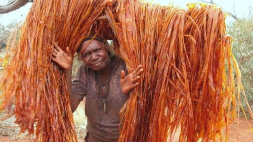 Tjanpi Desert Weaver, Ivy Laidlaw, working to create artwork using bush-dyed raffia. (Tjanpi Desert Weavers)