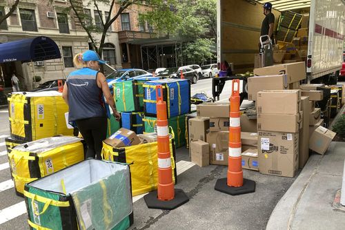An Amazon worker sorts deliveries on a street corner on New York's Upper West Side, Aug. 14, 2023. 