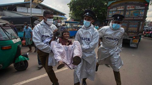 Sri Lankan police officials detain a man who violated the COVID-19 guidelines imposed by the authorities to curb the spread of the coronavirus in Colombo.