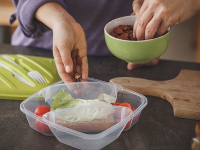 Woman packing lunchbox in kitchen