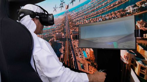 A man experiences a driving simulator of a flying taxi at the Dubai Roads and Transportation Authority's stand during the World Government SummitWLD in Dubai.
