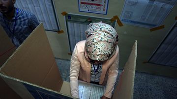 An Iraqi woman casts her vote in the country's parliamentary elections in Baghdad, Iraq, Saturday, May 12, 2018. Polls opened across Iraq on Saturday in the first national election since the declaration of victory over the Islamic State group. (AP Photo/Khalid Mohammed