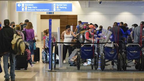 Passengers gather at Orlando International Airport in Florida today.