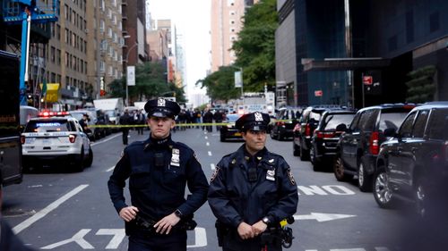 Police stand guard in a closed street after a bomb alert at the Time Warner offices in New York.