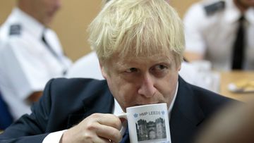 Britain's Prime Minister Boris Johnson takes a drink from a prison mug as he talks with prison staff during a visit to Leeds prison, Northern England, last week.