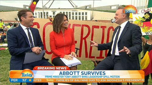 Karl Stefanovic and Lisa Wilkinson share a laugh with Labor MP Anthony Albanese as protesters assemble in the background. (9NEWS)