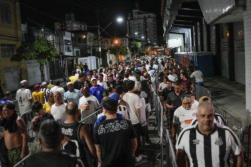 Soccer fans line up to attend the funeral procession of late Brazilian soccer legend Pele at Vila Belmiro stadium where his wake was held in Santos, Brazil, early Tuesday, Jan. 3, 2023.