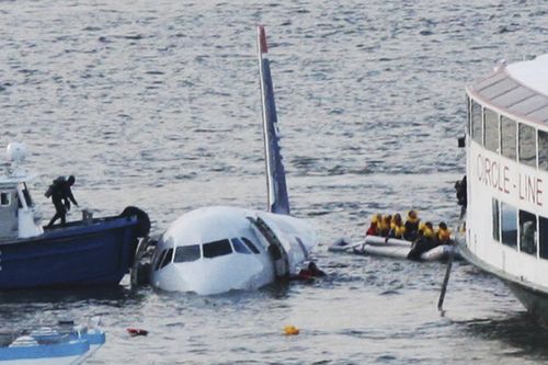 A diver (left) aboard an NYPD vessel prepares to rescue passengers of the US Airways plane that landed on the Hudson River. 