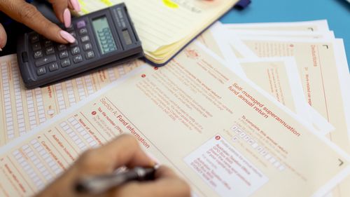 Generic picture of someone filling out a tax return.