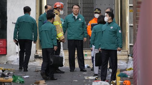 South Korean President Yoon Suk Yeol, center, visits the scene where dozens of people died and were injured in Seoul, South Korea.