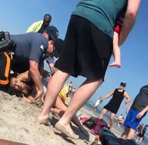 Footage shows two New Jersey police officers punch a woman in the head at a beach over Memorial Day weekend. Picture: Facebook