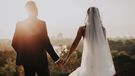 Bride and groom holding hands.