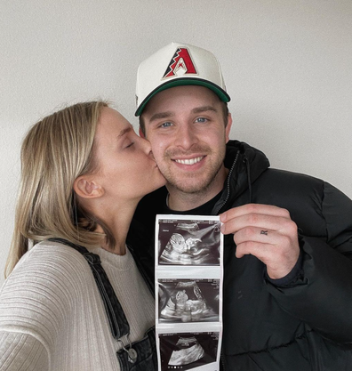 Digital creator, Rachel Connelly, and her partner holding up images of ultrasound scan. 