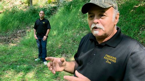 Dennis Parada, right, and his son Kem Parada stand at the site of the FBI's dig for Civil War-era gold in Dents Run.