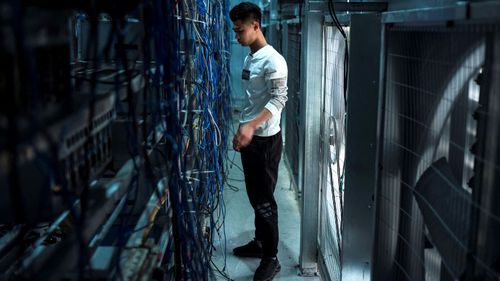 A worker adjusts cryptocurrency mining rigs at a cryptocurrency farm in Dujiangyan in China's southwestern Sichuan province.