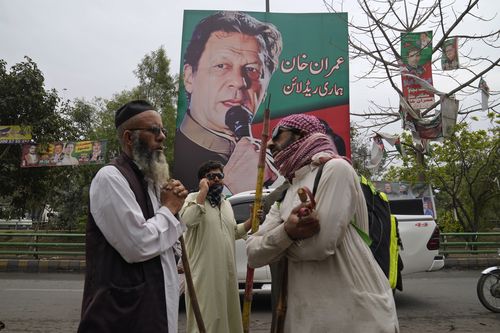 Des partisans de l'ancien Premier ministre Imran Khan se rassemblent avec des bâtons près de la résidence du Khan, à Lahore, au Pakistan, le vendredi 17 mars 2023. 
