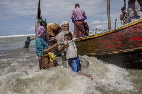 An elderly Rohingya Muslim man helps a boy get off a boat after they arrived from Myanmar to Bangladesh in Shah Porir Dwip. (AP)