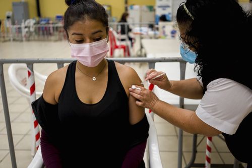 A healthcare worker administers a booster dose of a COVID 19 vaccine at a temporary vaccine centre in Guatemala City, Tuesday , March 1, 2022