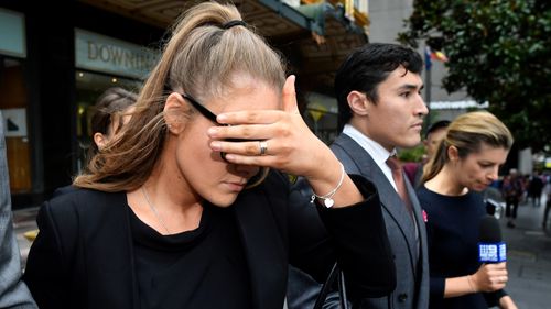 Sarah Jane Chisholm Rogers, 24, covers her face as she leaves court in Sydney.