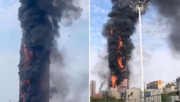 Images taken from videos posted to social media show plumes of black smoke billow from a building in China.