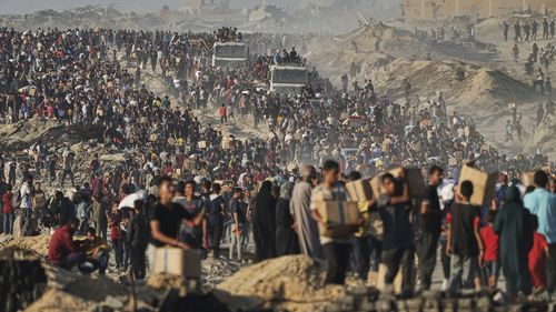 FILE - Palestinians carry sacks and boxes of food and humanitarian aid, unloaded from a World Food Program convoy that was heading to Gaza City in the northern Gaza Strip, Monday, June 16, 2025. (AP Photo/Jehad Alshrafi, file)