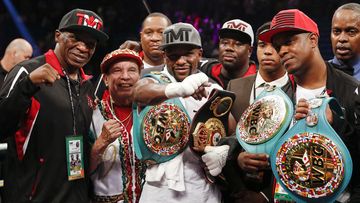 The Mayweather "Money Team" celebrate the title win. (AAP)