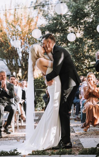 Hannah and Simon kiss on their wedding day.