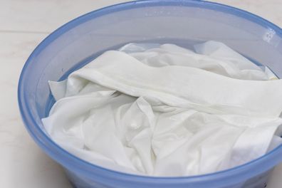 White clothes soaked in water in a basin.