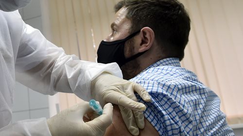 A nurse inoculates volunteer Ilya Dubrovin, 36, with Russia's new coronavirus vaccine in a post-registration trials at a clinic in Moscow on September 10, 2020. 