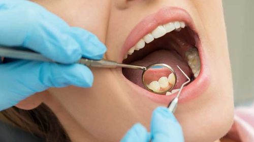 Generic image of a woman getting her teeth professionally cleaned by dentist.