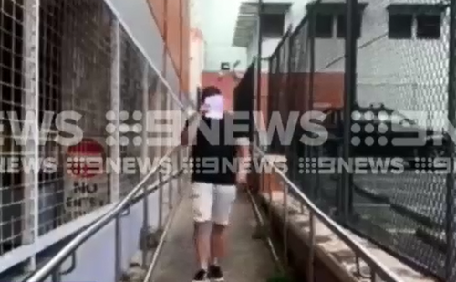 Lavelle covered his face as he was released from custody this morning. (9NEWS)